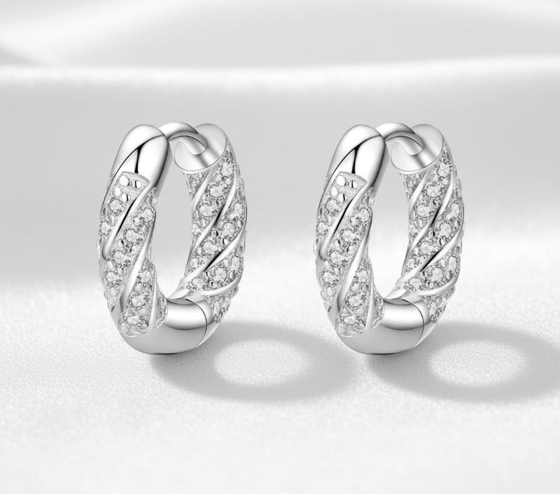 Pair of silver hoop earrings with diamond-like stones on a white background