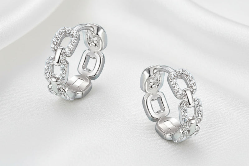 Pair of silver chain-link earrings on a white background