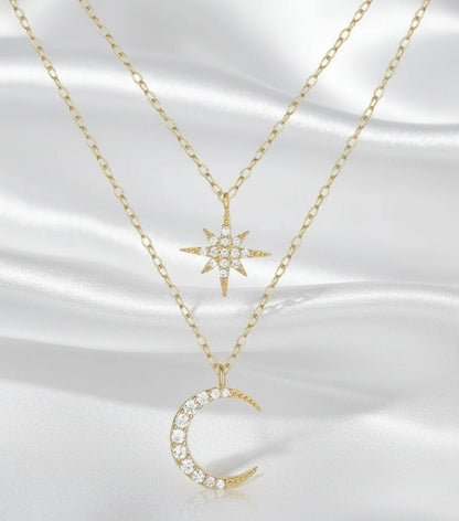 Two gold necklaces with star and moon pendants on a white background