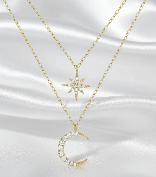 Two gold necklaces with star and moon pendants on a white background