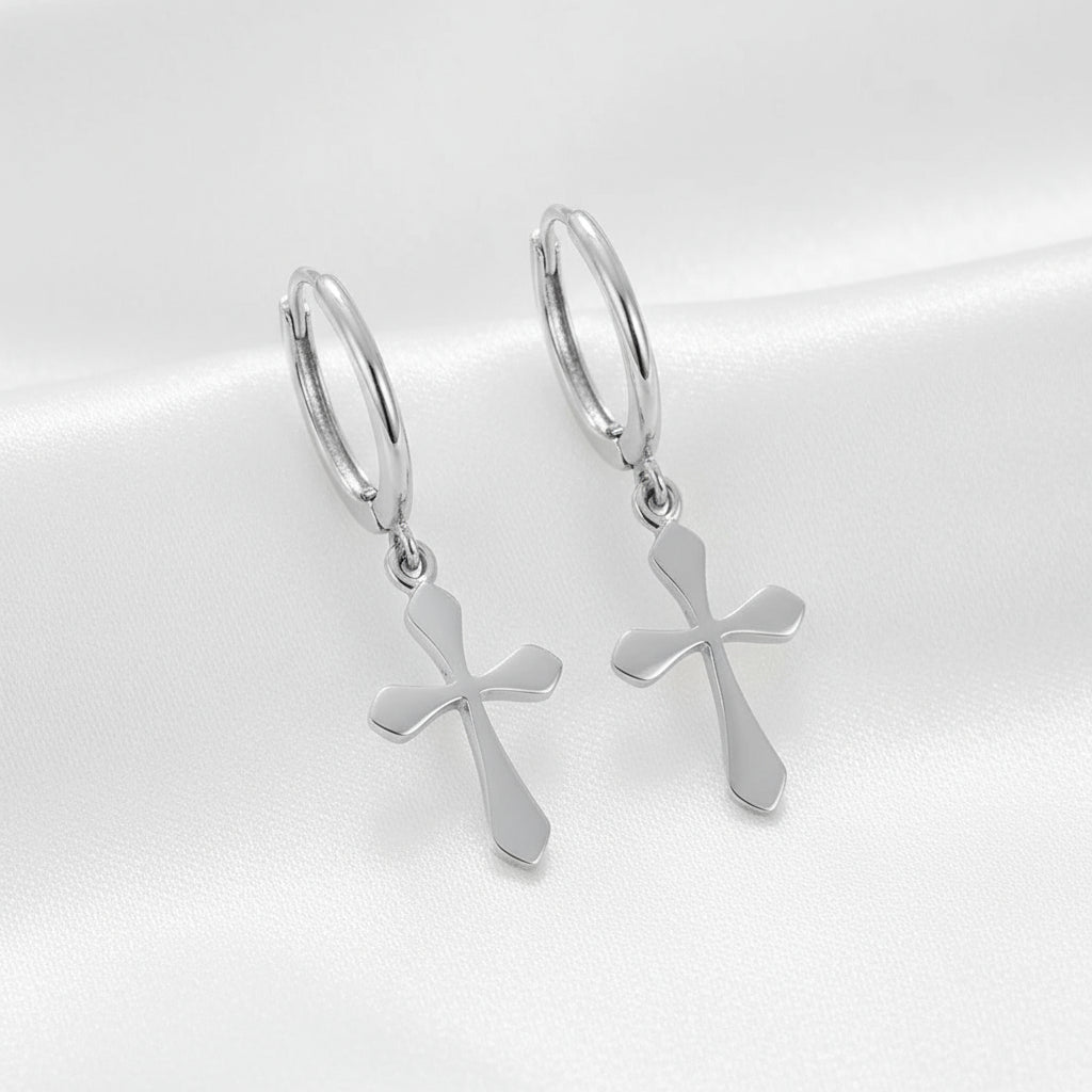 Silver hoop earrings with cross charms on a white background