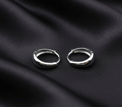Two silver hoop earrings on a gray background