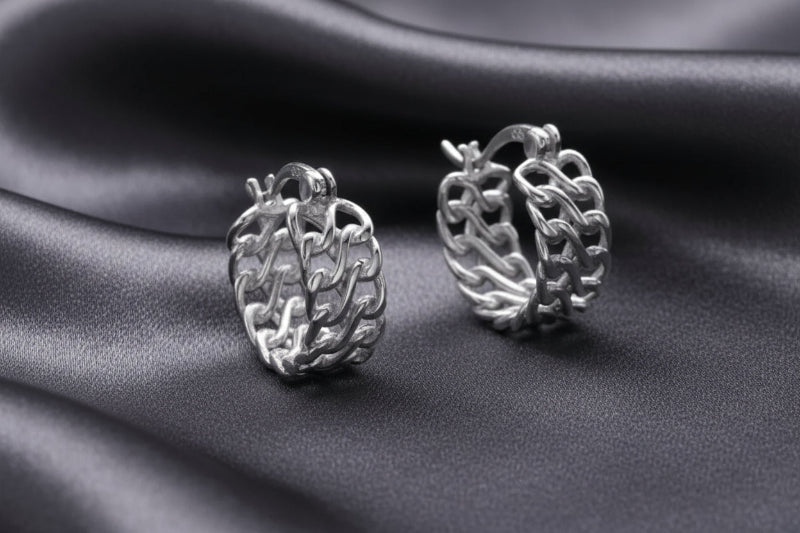 Pair of silver chain hoop earrings on a light gray background