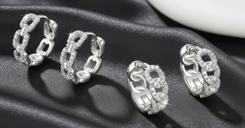 Set of silver hoop earrings on a dark fabric background