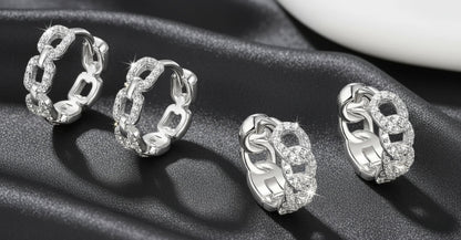 Set of silver hoop earrings on a dark fabric background