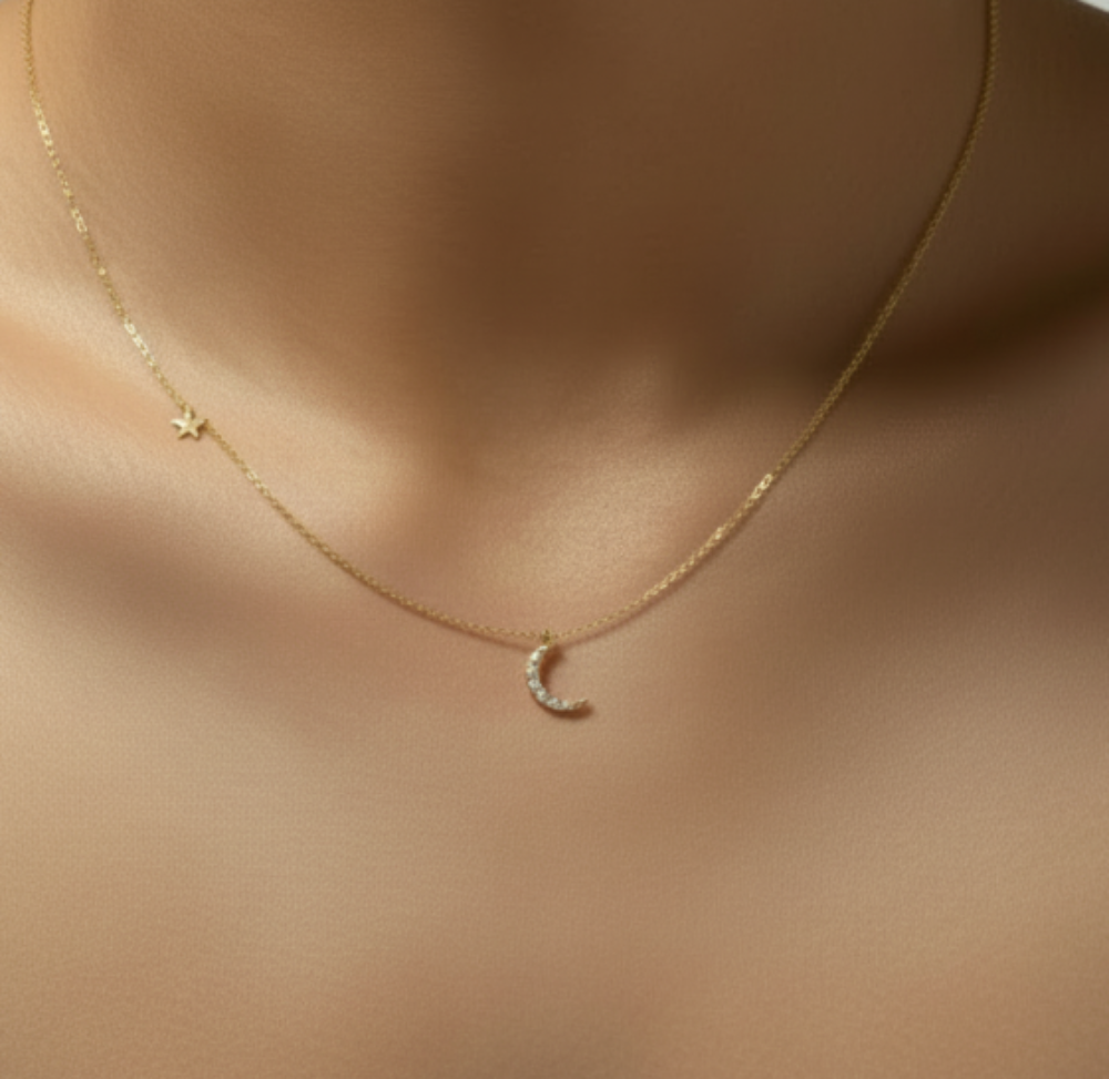 Gold necklace with a crescent moon pendant on a mannequin wearing a pink top.