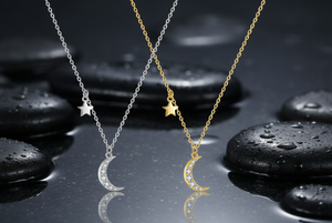 Two moon-shaped necklaces, one silver and one gold, on a white background.