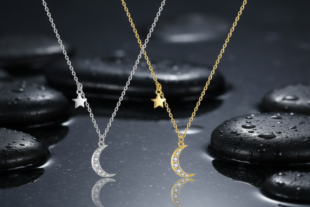Two moon-shaped necklaces, one silver and one gold, on a white background.