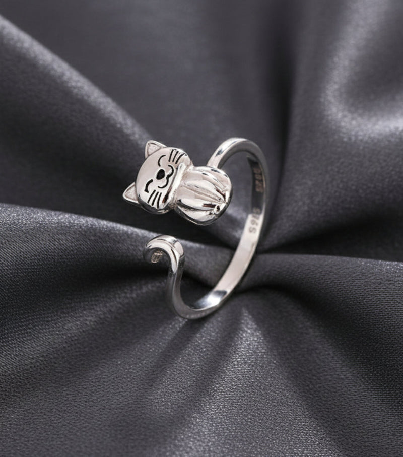 Silver cat-shaped ring on a beige and grey background