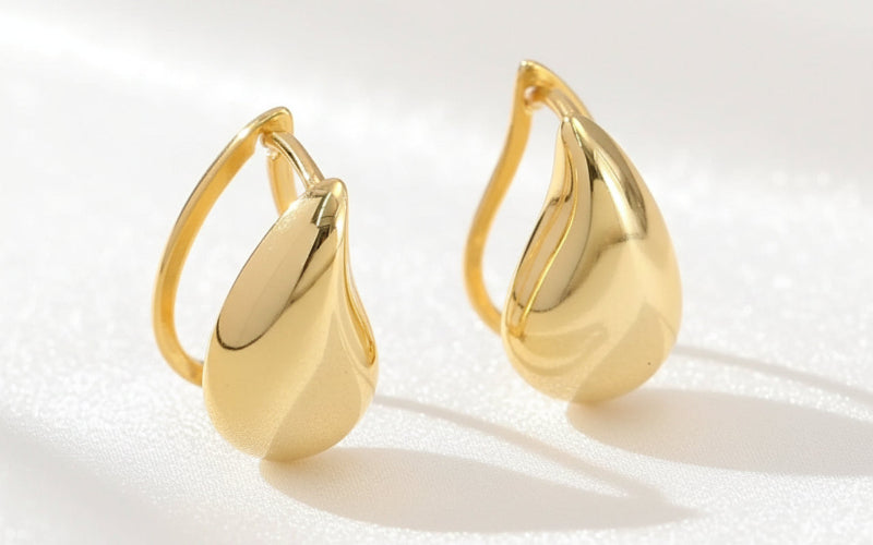 Pair of gold earrings on a textured white background