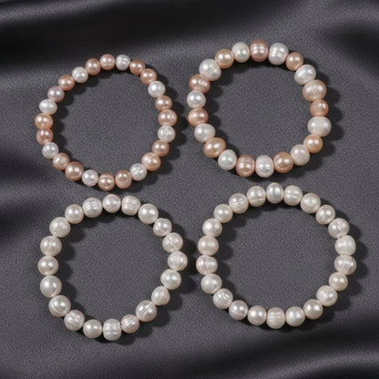 Three pearl necklaces on a grey surface