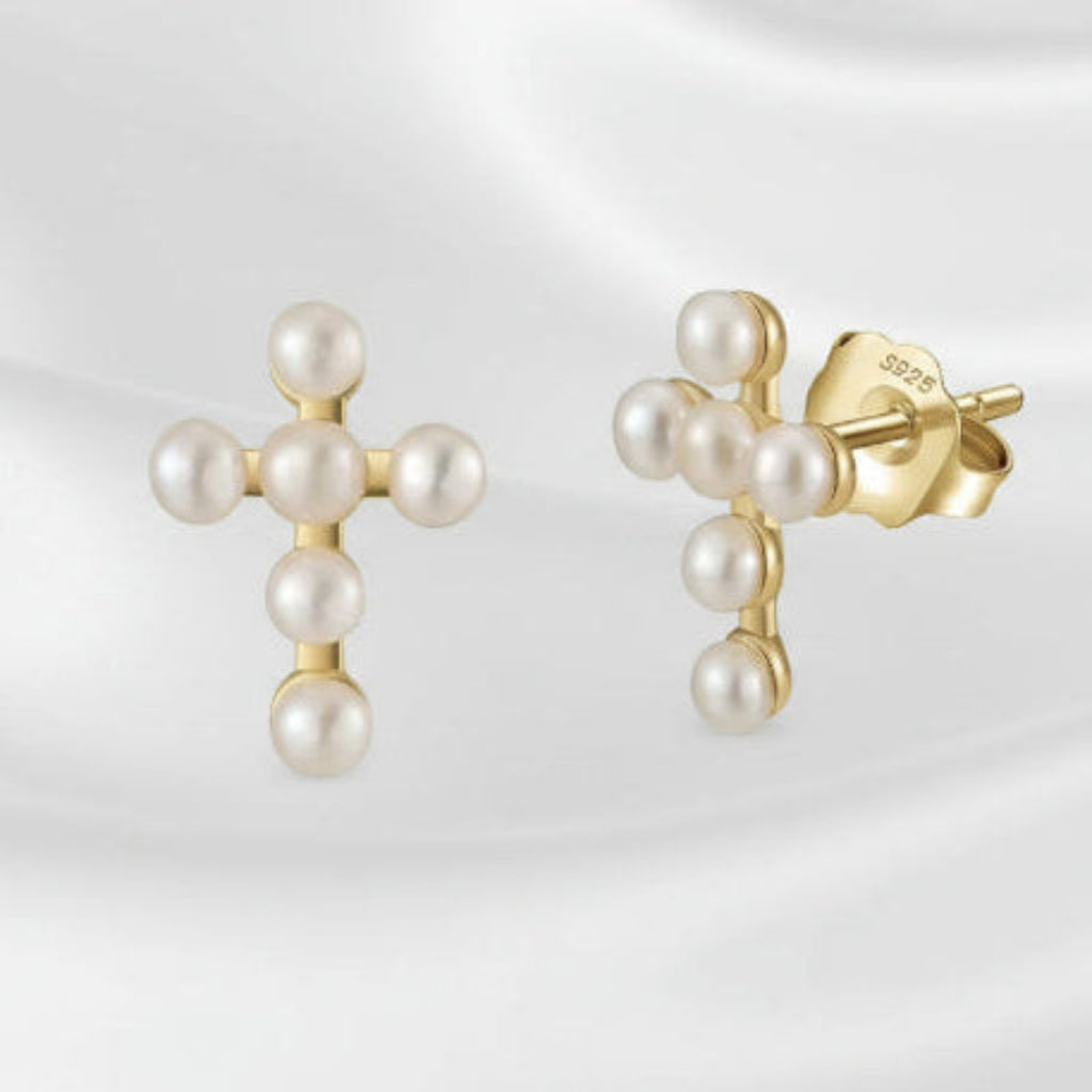 Gold earrings with pearls on a white background