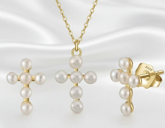 Gold and pearl jewelry set including earrings and a necklace on a white background