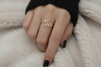 Gold leaf ring on a finger against a white background