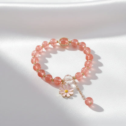Bracelet with pink beads and a floral charm on a light background