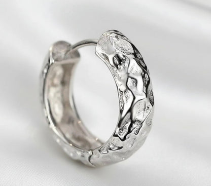 Silver hoop earring on a white background