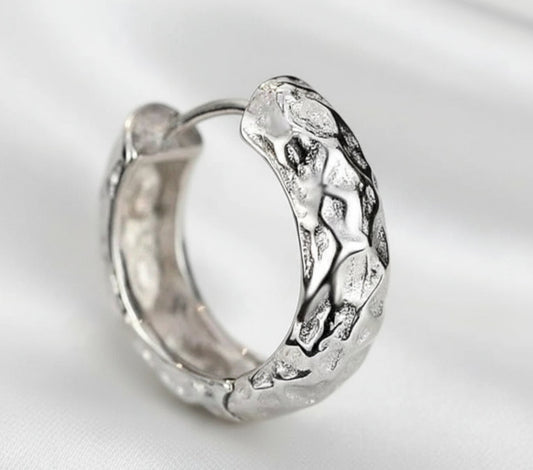 Silver hoop earring on a white background