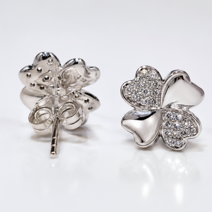 Four leaf sterling silver stud earrings with alternating petals polishes and cubic zirconia on white background
