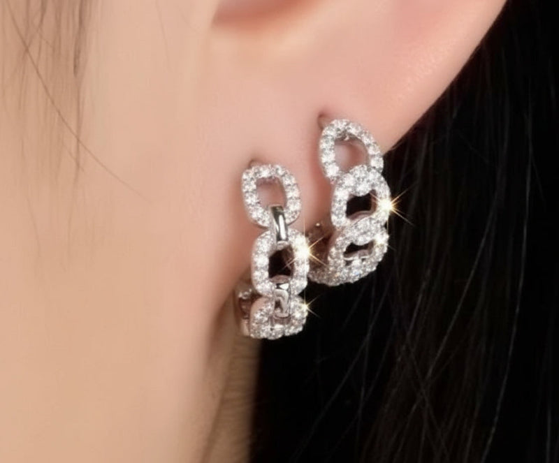 Close-up of a person wearing a pair of sparkling earrings.