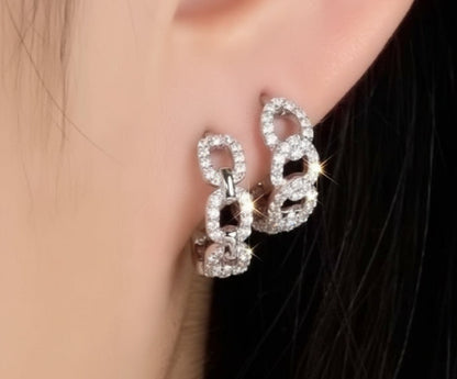 Close-up of a person wearing a pair of sparkling earrings.