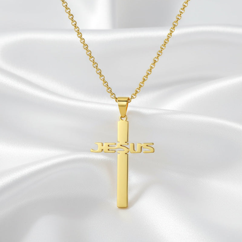 Gold cross necklace with 'JESUS' engraving on a white background