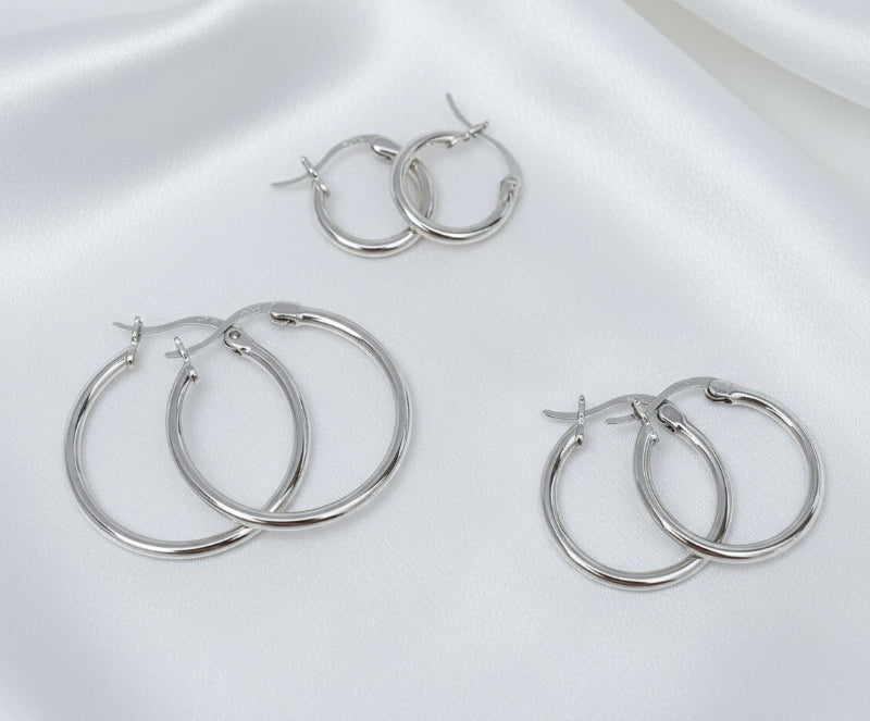 Set of silver hoop earrings on a white background