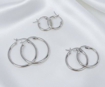 Set of silver hoop earrings on a white background