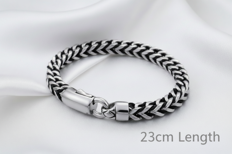 Silver and black braided bracelet on a white background