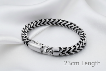 Silver and black braided bracelet on a white background