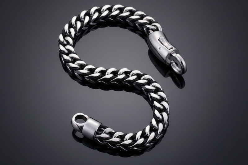 Silver chain bracelet on a reflective black surface