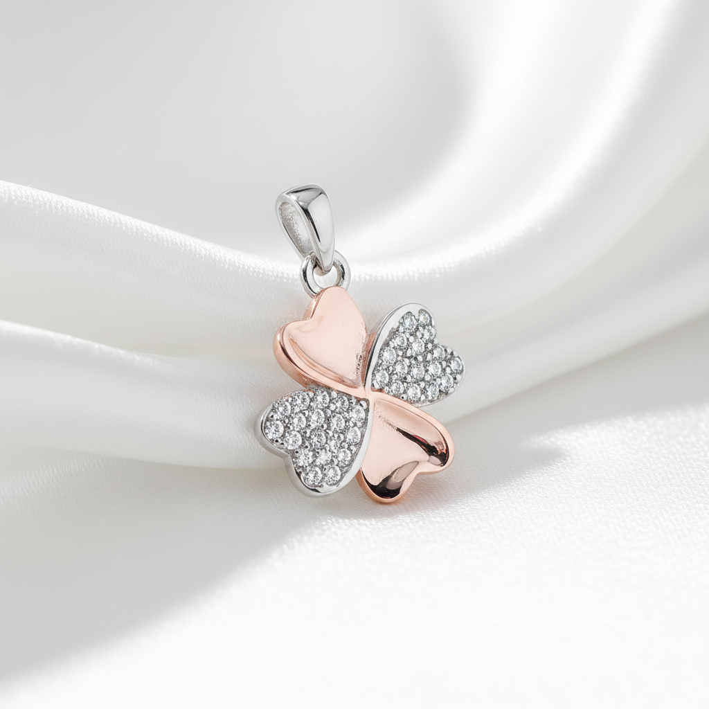 four leaf clover pendant on white surface rose gold plate and silver pave set with cubic zirconia