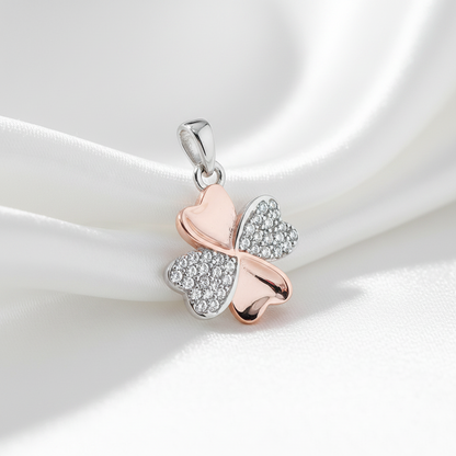 four leaf clover pendant on white surface rose gold plate and silver pave set with cubic zirconia