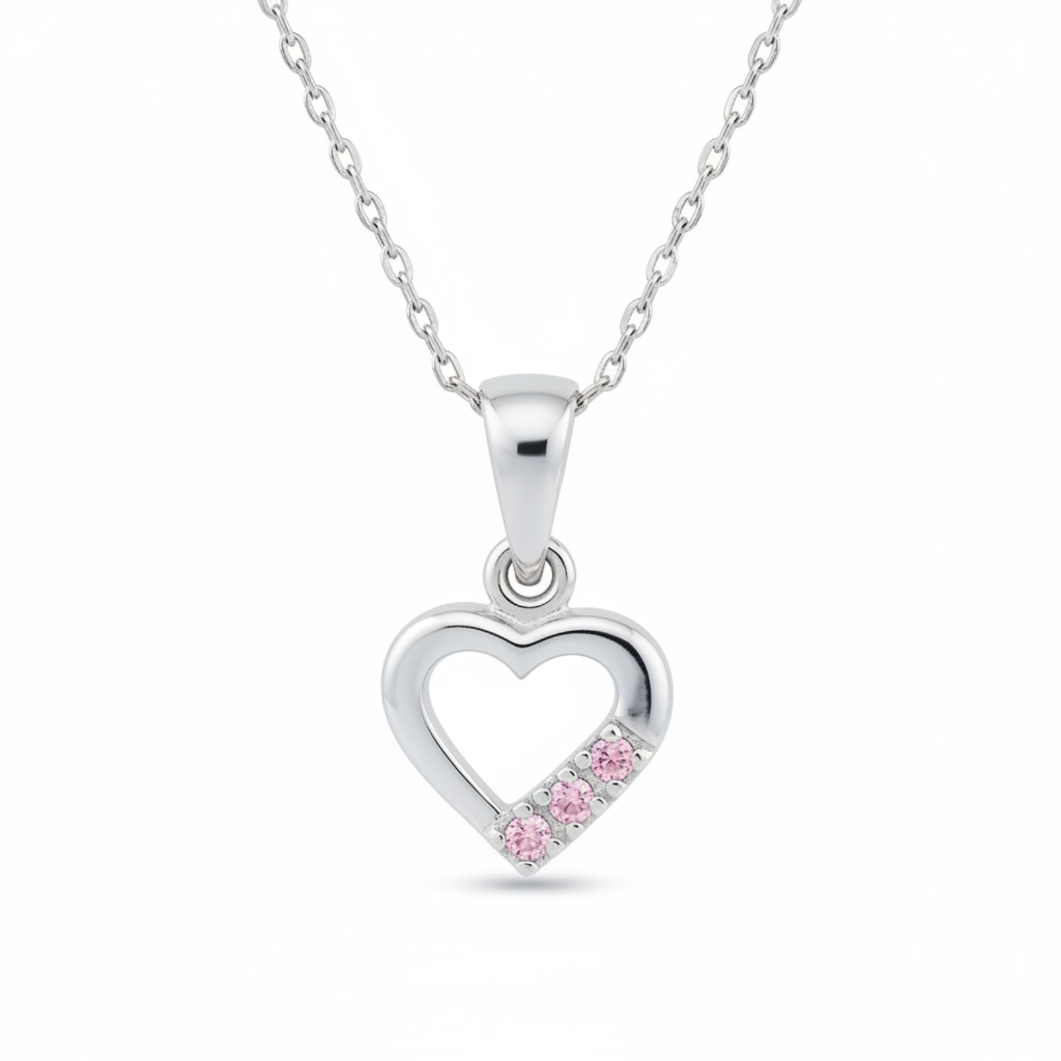 A silver heart-shaped pendant necklace featuring three small pink gemstones set along the bottom right edge of the heart, suspended from a delicate silver chain against a white background.