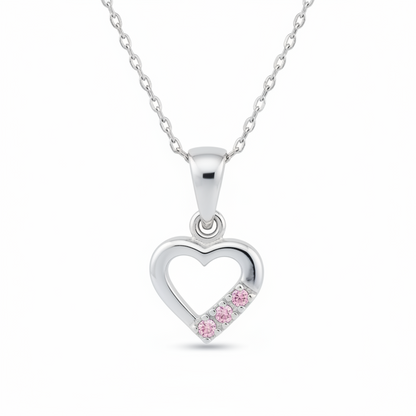 A silver heart-shaped pendant necklace featuring three small pink gemstones set along the bottom right edge of the heart, suspended from a delicate silver chain against a white background.