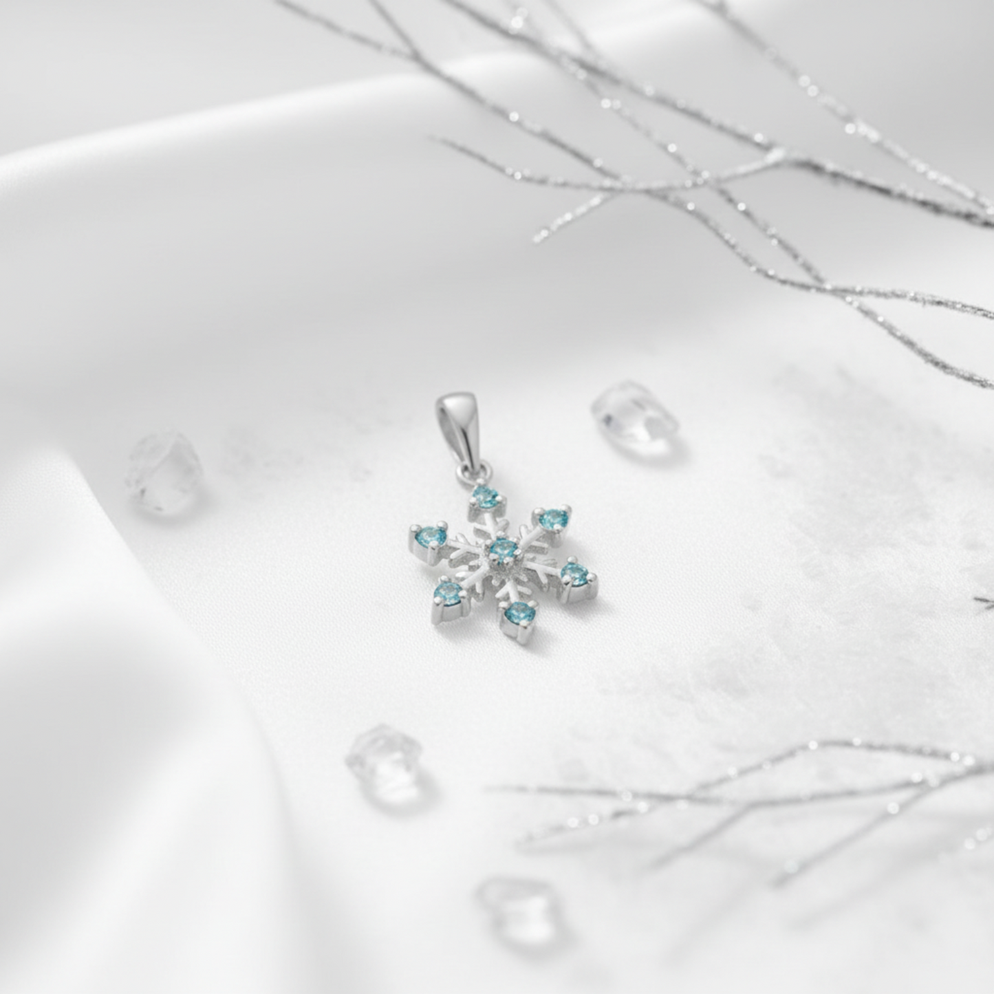 Aqua cubic zirconia silver snowflake pendant on a white background