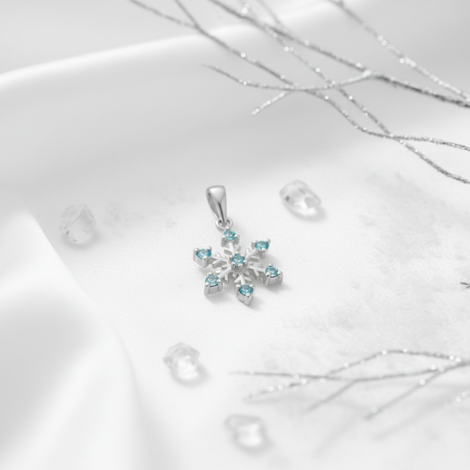 Aqua cubic zirconia silver snowflake pendant on a white background