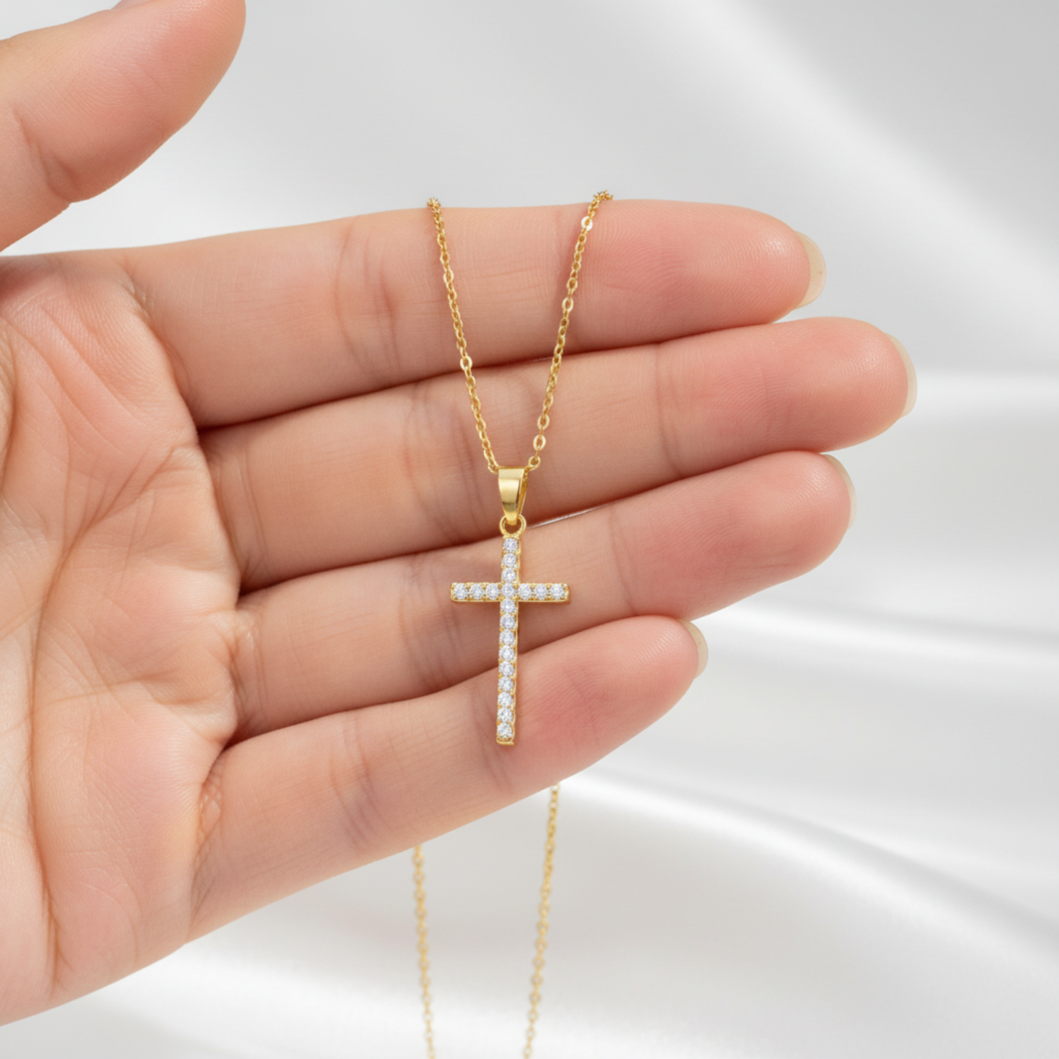 Cross pendant held in hand