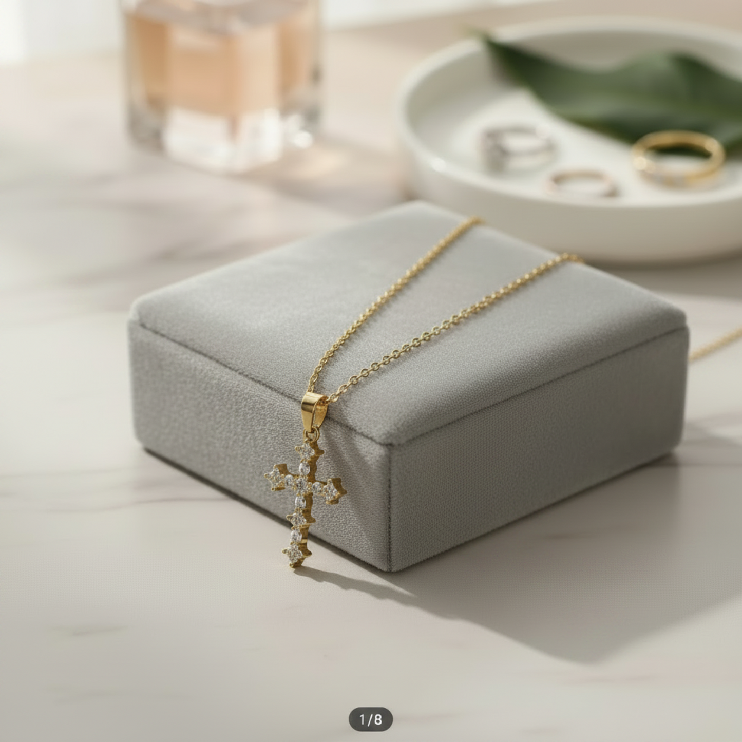 Cross pendant on grey box, chain tucked