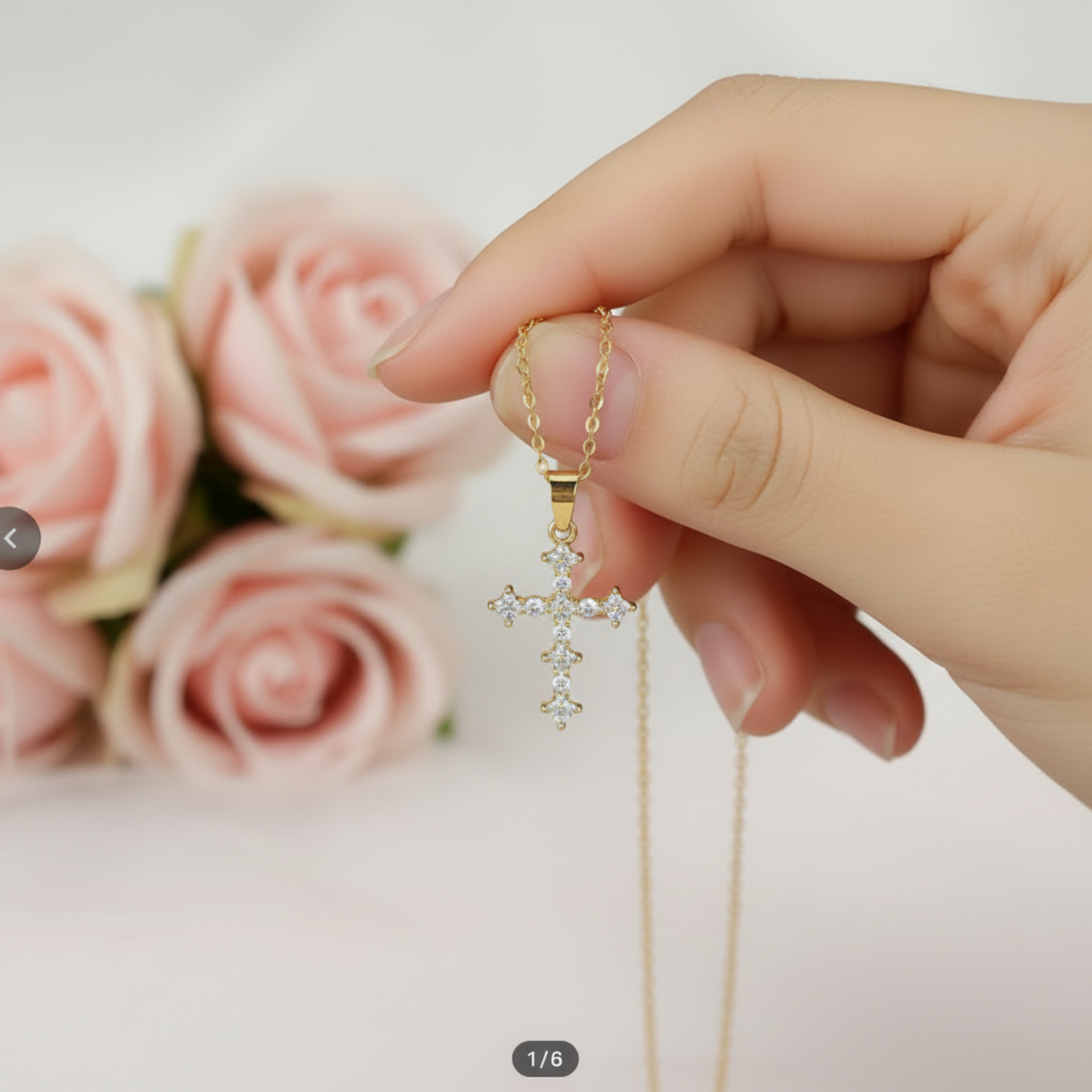 Hand holding cross pendant