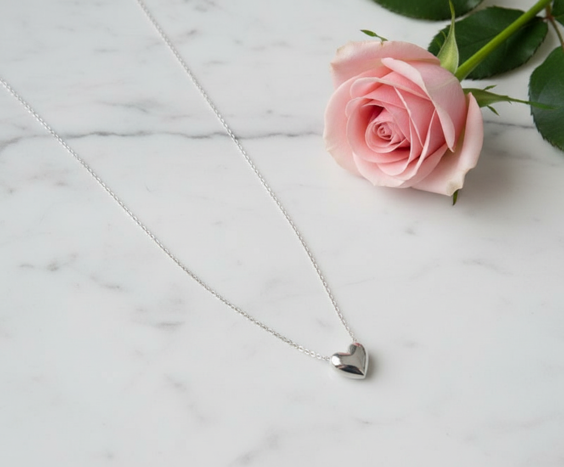 Heart necklace on marble with rose