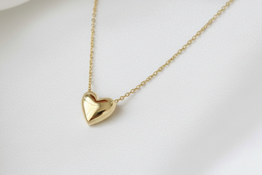 Gold heart-shaped pendant necklace on a light background