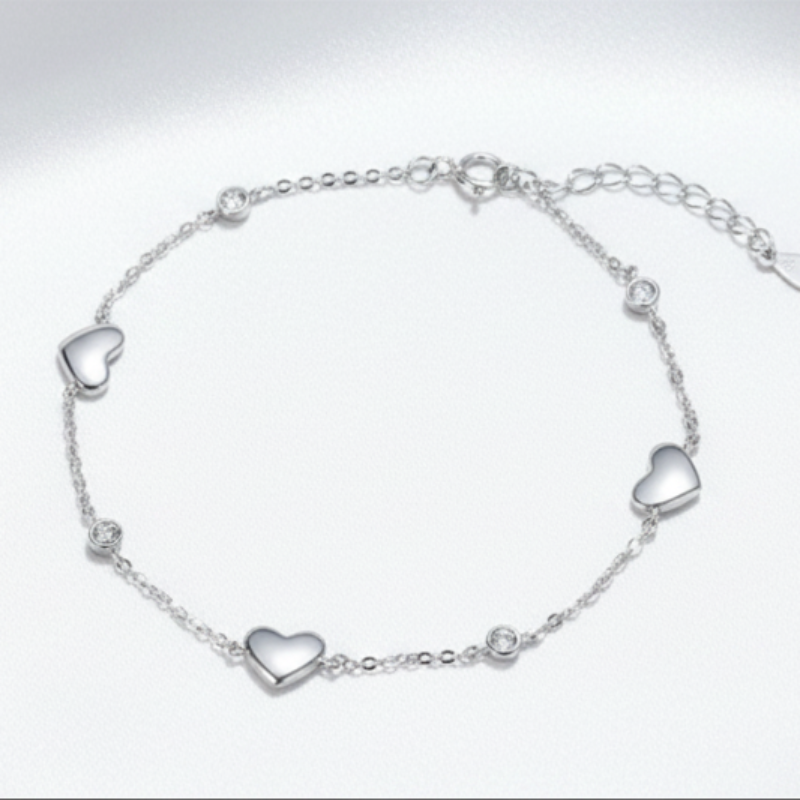 Silver bracelet with heart-shaped charms on a white background