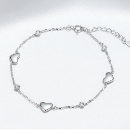 Silver bracelet with heart-shaped charms on a white background