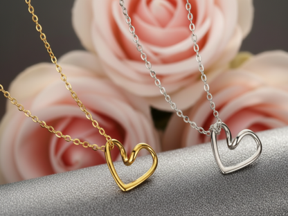 Gold and silver heart-shaped pendants on chains blurred roses in the background