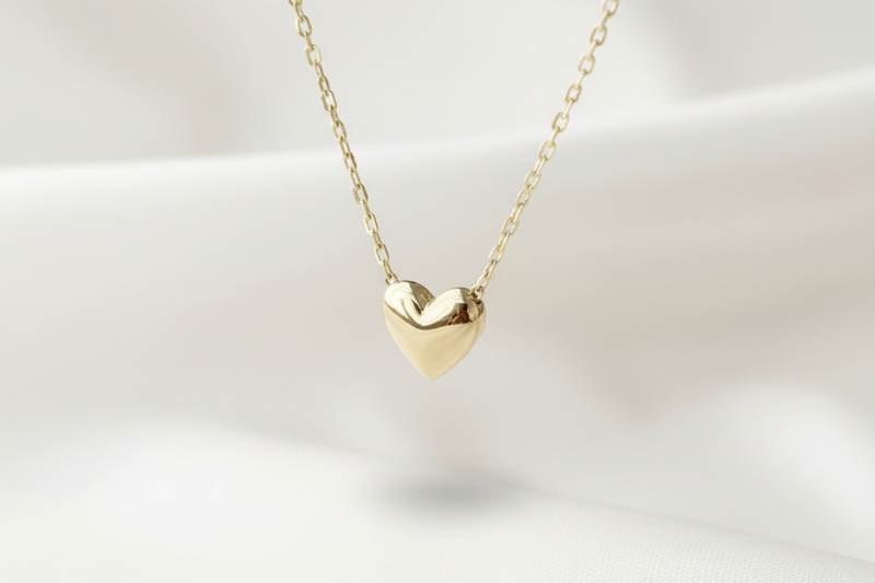 Gold heart-shaped necklace on a light background