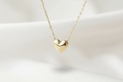 Gold heart-shaped necklace on a light background