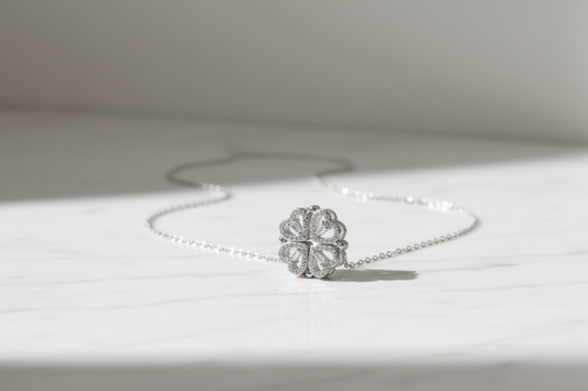 Floral pendant necklace in silver, on a light gray background.