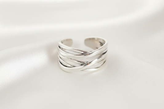 Silver ring with a twisted design on a gray background