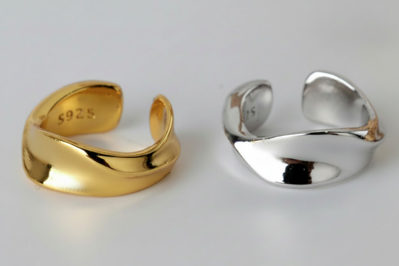 Gold and silver open rings on a light gray background