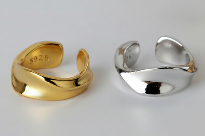 Gold and silver open rings on a light gray background